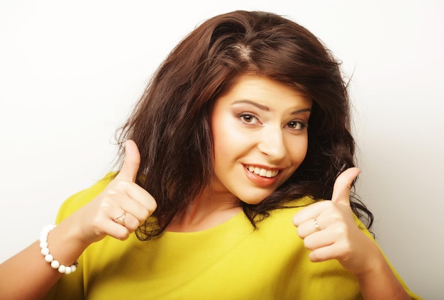 Lovely woman showing victory or peace sign over white background