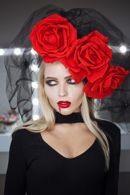 Lovely woman with blood spill on face wearing rose headgear and looking at camera