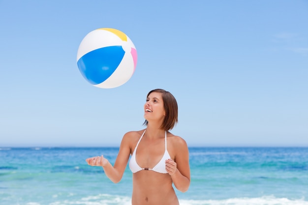 Bella donna con la sua palla sulla spiaggia