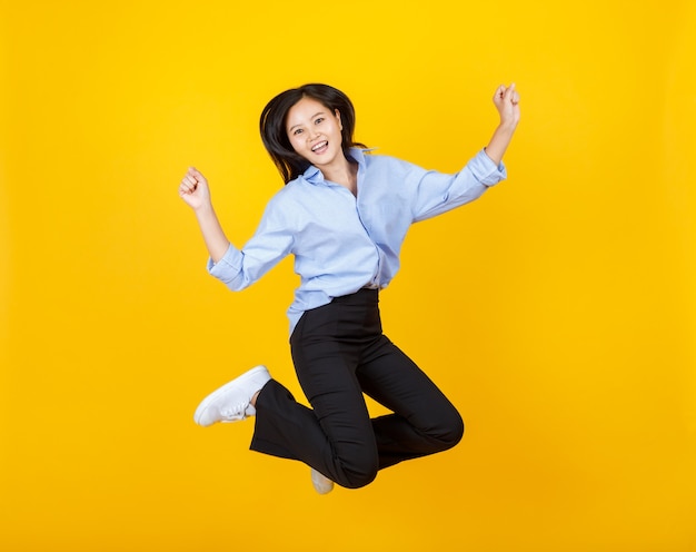 Lovely young Asian girl as business secretary enjoy funny game play of jumping and happy upward fly with smile and lively on dress of long sleeve shirt and trousers for isolated fashion portrait