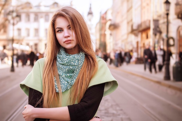 Photo lovely young  blonde woman in a coat at the street