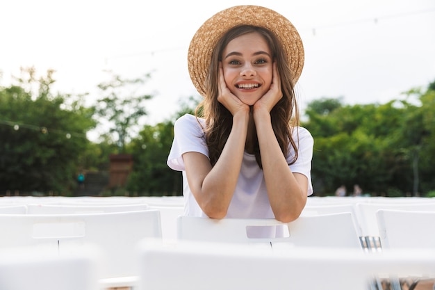 Lovely young girl sitting at the city park outdoors in summer