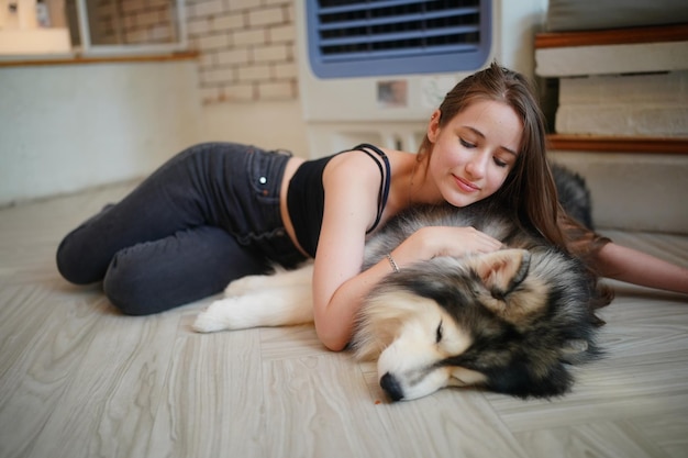 Lovely young woman playing with her dog