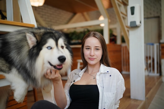 Lovely young woman playing with her dog