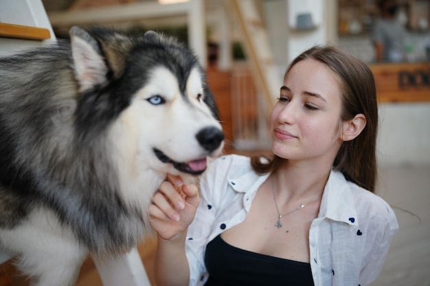 Lovely young woman playing with her dog