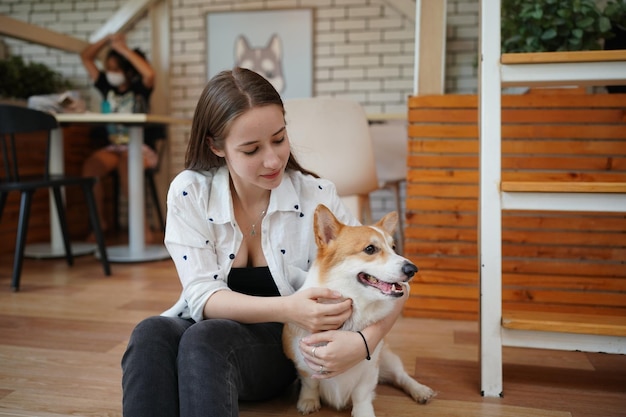 Lovely young woman playing with her dog