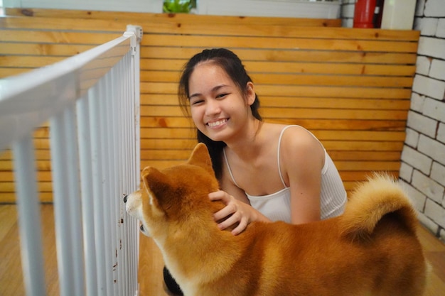 Lovely young woman playing with her dog