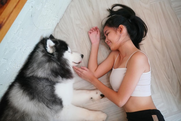Lovely young woman playing with her dog