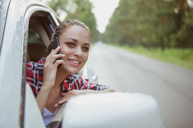 彼女の車のロードトリップに素敵な若い女性