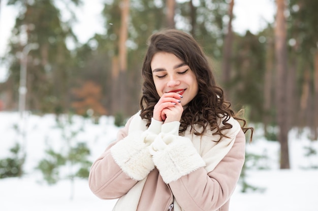 Lovely young woman walking at the winter park. Space for text