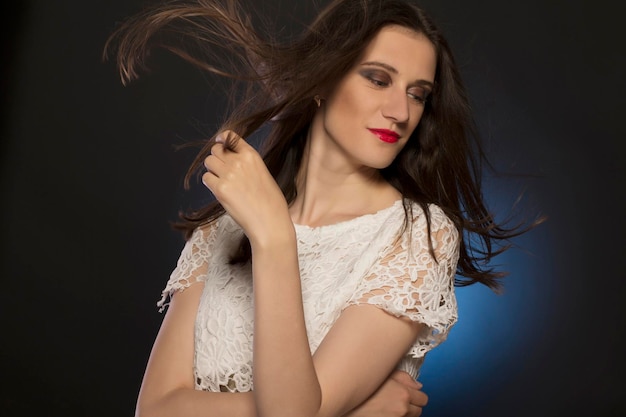 Lovely young woman with hair motion at studio