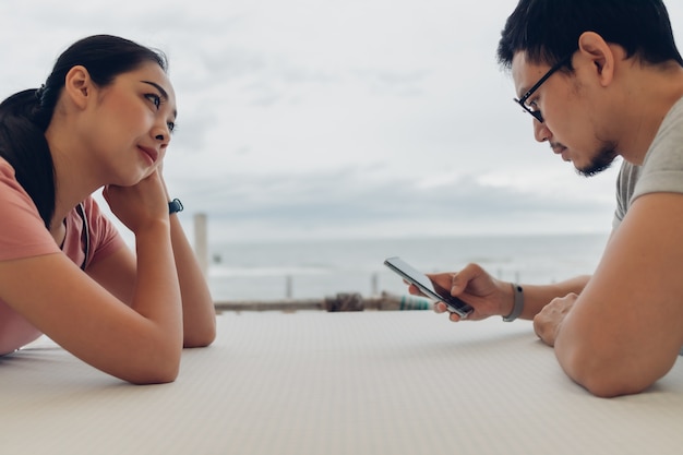 Lover couple sit at the table on the beach.