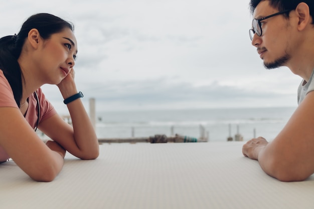 Lover couple sit at the table on the beach.