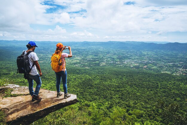 恋人の女性と男性のアジア人旅行は休暇中にリラックスします。崖の上にあります。