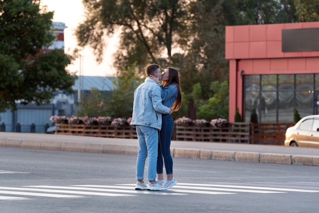 Lovers kiss in middle of street in the rays of the setting sun.