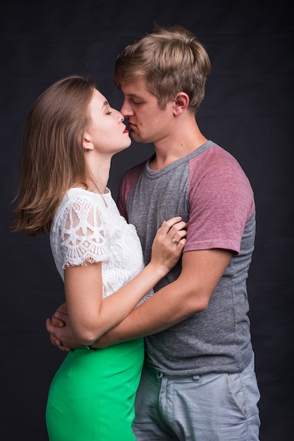 Lovers kissing each other on black in studio