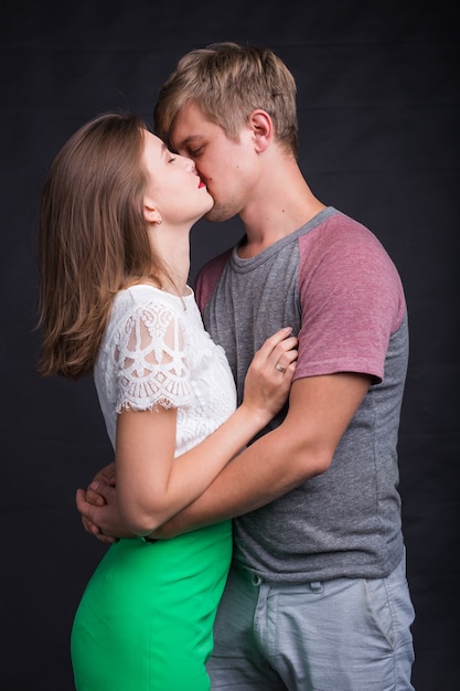 Lovers kissing each other on black in studio