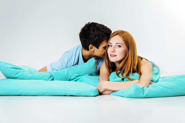 Lovers lie comfortably on cushions