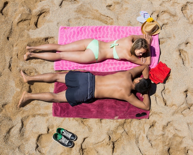 海のビーチで砂の上に休む恋人