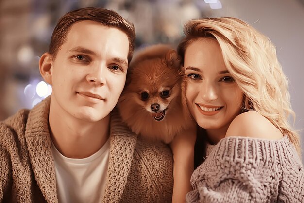 lovers small dog New Year's interior / boy and girl hug Christmas evening, cute dog family