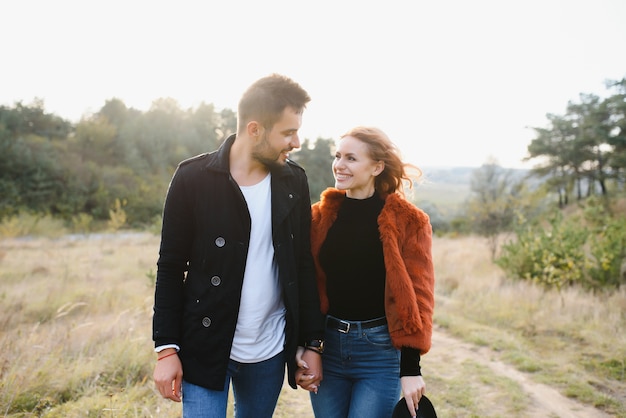 Lovers walking hand in hand in autumn park