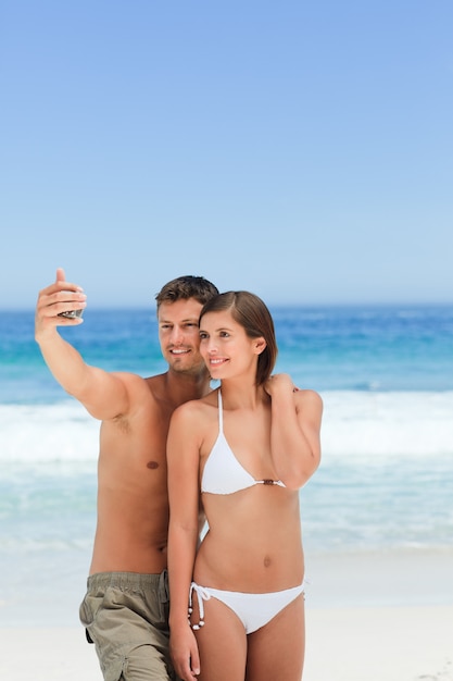 Amanti con la loro macchina fotografica in spiaggia