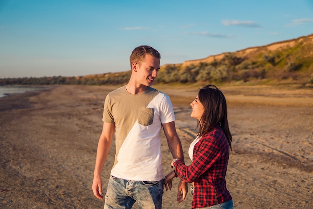 Lovestory of young beautiful couple on the beach On the Sunset