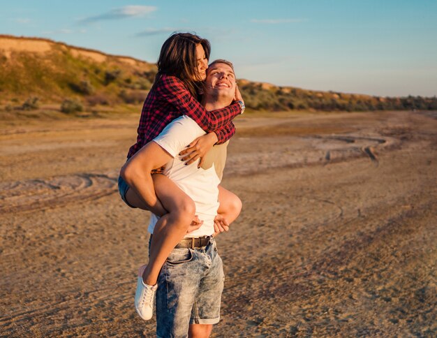 Storia d'amore di una giovane e bella coppia che fa sulle spalle la spiaggia al tramonto