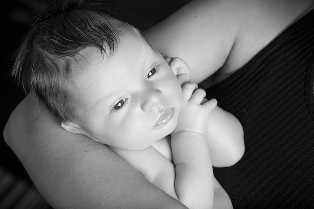 Loving baby with open eyes in mother's hands Closeup picture