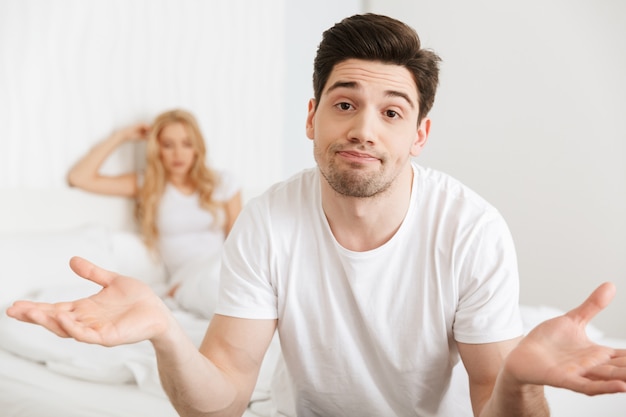 Loving couple in bed indoors at home