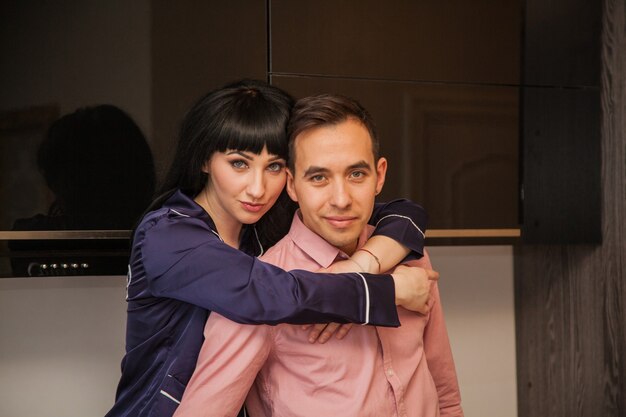 A loving couple in a black kitchen. Morning at home.