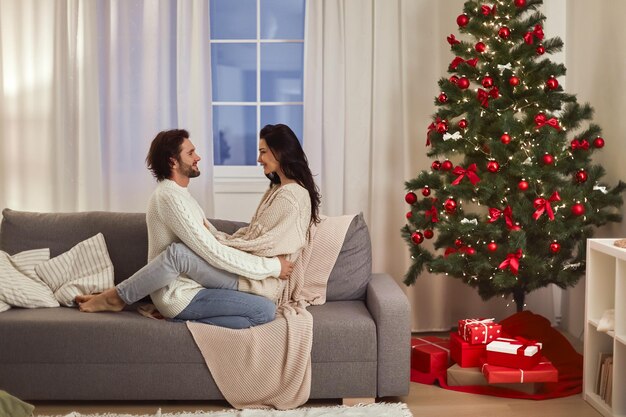 Loving couple celebration new year near christmas tree at home