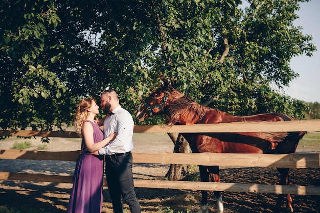 A loving couple on a date. Horseback riding. Purple dress.