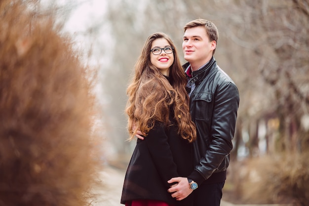 Loving couple embracing on fir trees