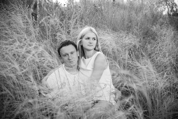 Loving couple on grass in summer.  Black and white photography