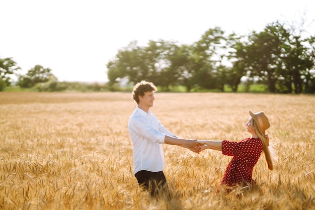 愛情のあるカップルが麦畑で楽しんでリラックスを楽しんでいます