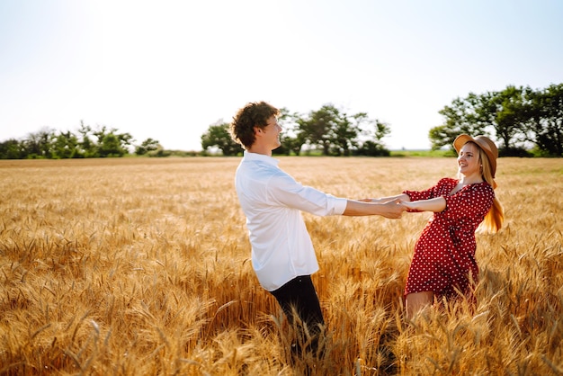 愛情のあるカップルが麦畑で楽しんでリラックスを楽しんでいます