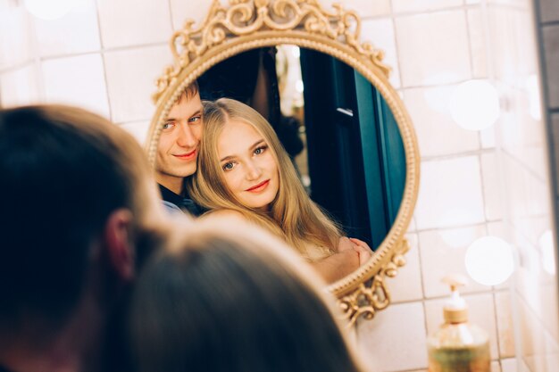 Loving couple hugging in the bathroom mirror. Lifestyle