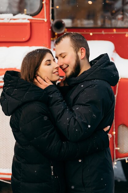 A loving couple hugs on the background of a red bus. Valentine's Day. High quality photo