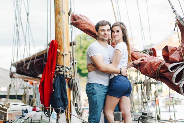 A loving couple hugs on a yacht in the summer