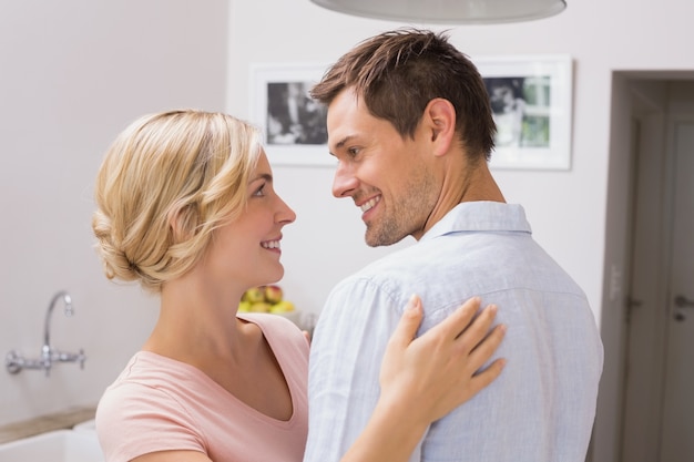 Loving couple looking at each other at home