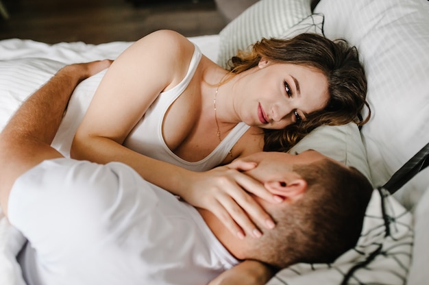 Loving couple lying on bed in the bedroom