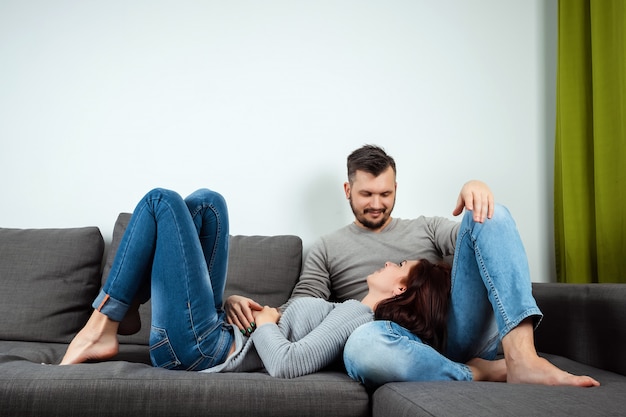 A loving couple lying on a bed at home