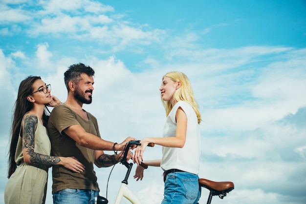 愛するカップルが自転車に乗って友達に会い、サイクリングの現代性と国の文化を楽しんでいます。