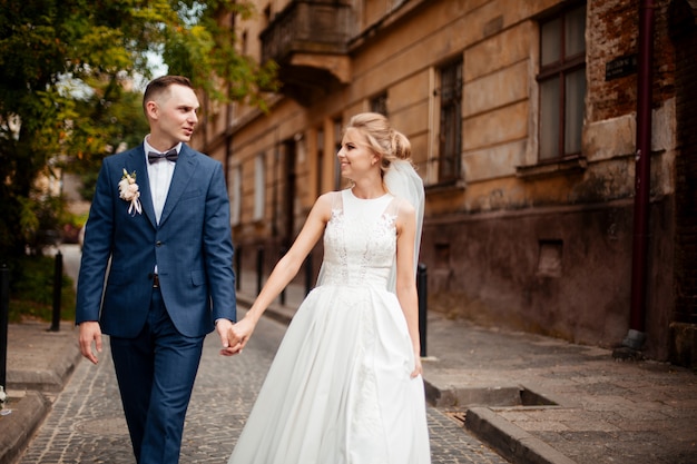 A loving couple of newlyweds walks in the city. Husband and wife on a walk