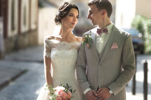 A loving couple of newlyweds walks in the city, and smile, 