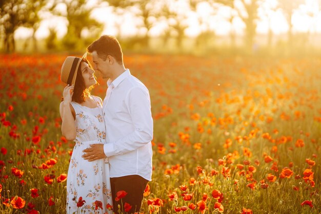 Loving couple in the poppy field at sunset Enjoying time together love and lifestyle