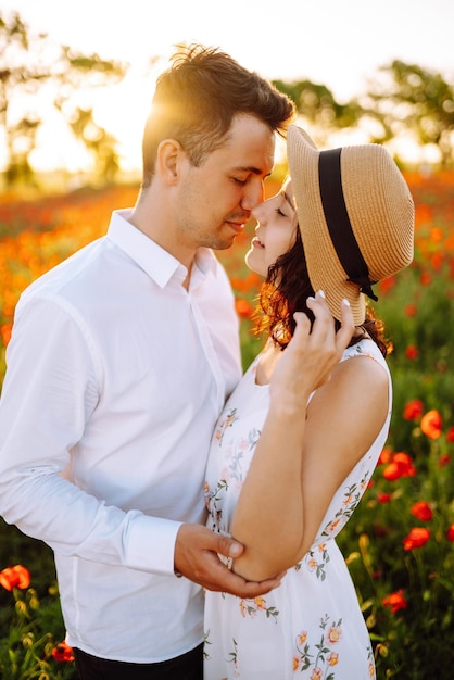 Loving couple in the poppy field at sunset Enjoying time together love and lifestyle