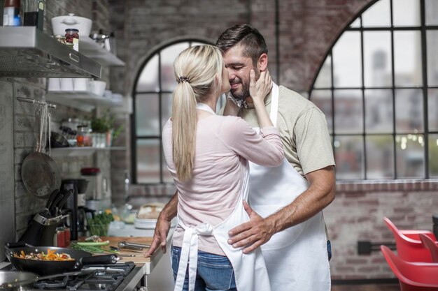 Loving couple preparing food in kitchen