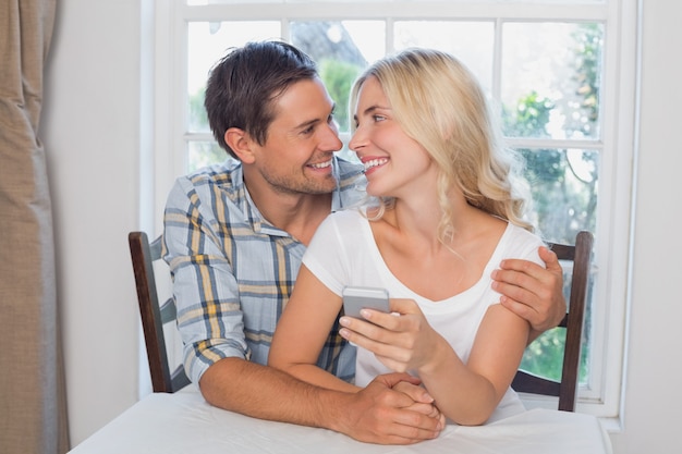 Photo loving couple reading text message together at home